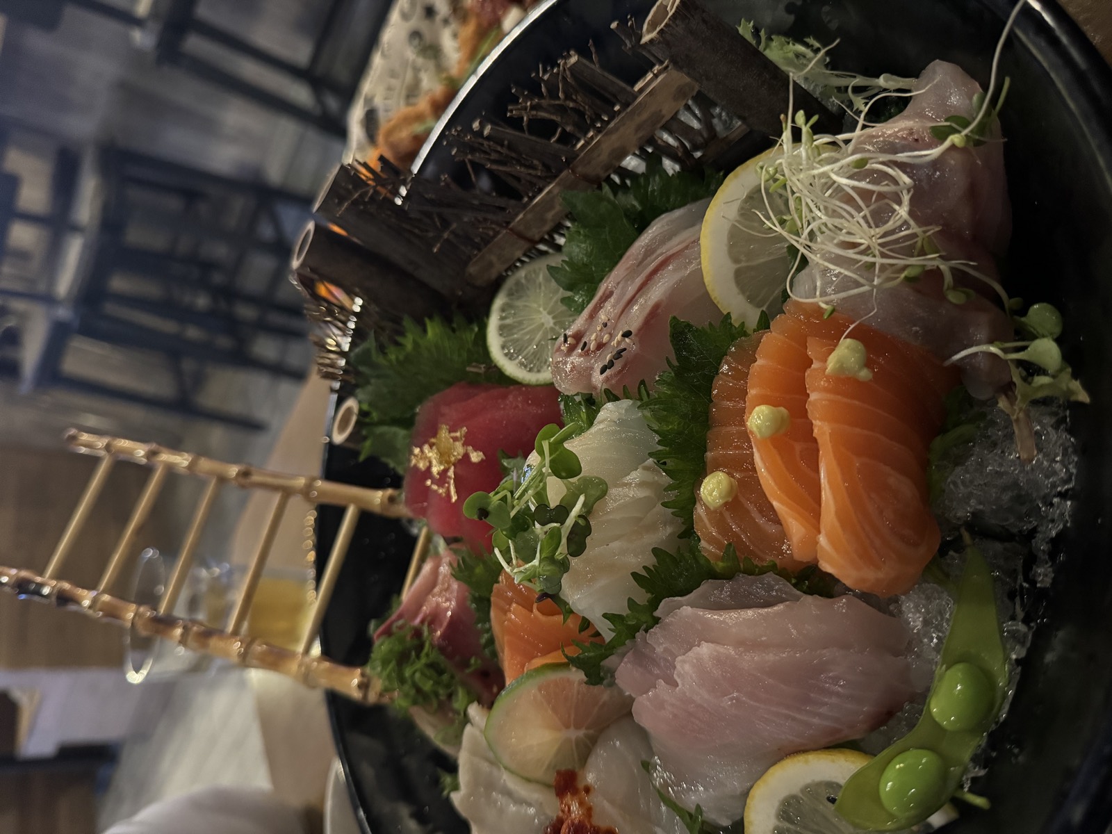 A sashimi moriawase platter stacked with salmon, tuna, yellowtail and citrus at the Sushikin bar